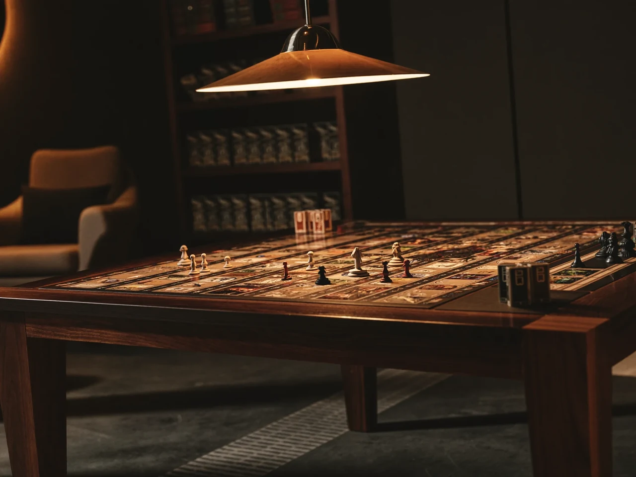 Strategiespiel auf dunklem Walnusstisch im warmen Licht einer Pendelleuchte, Regale im Hintergrund